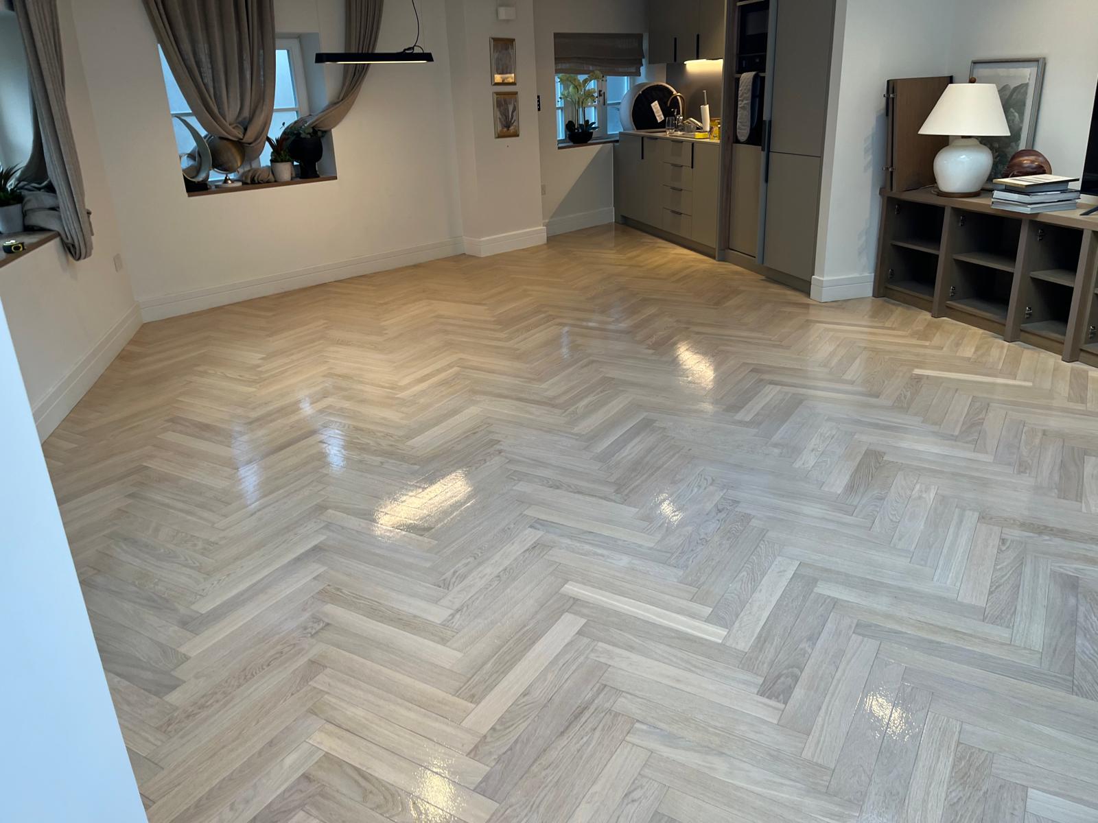 Parquet Floor Sanding in Lee on a light oak herringbone parquet floor in an open-plan kitchen and living room, restored to a smooth, glossy finish.