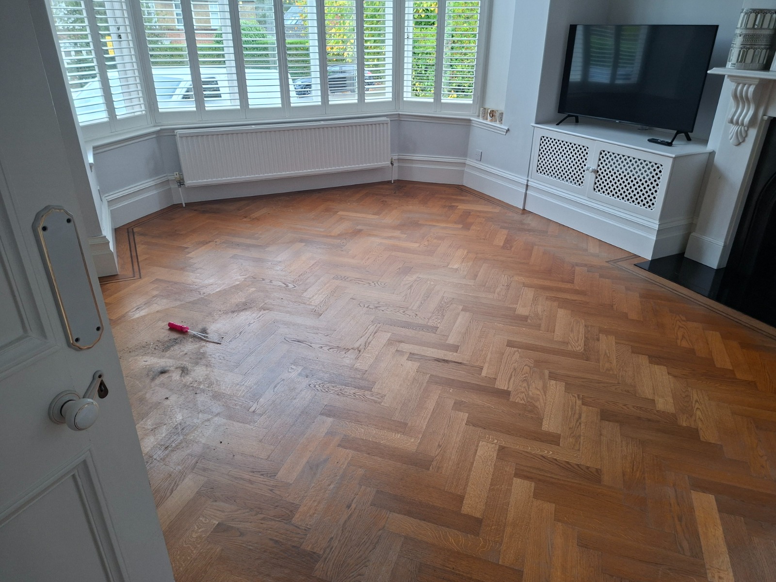Parquet Floor Sanding in Lee on an oak herringbone parquet living room floor showing worn and scratched blocks ready for restoration.