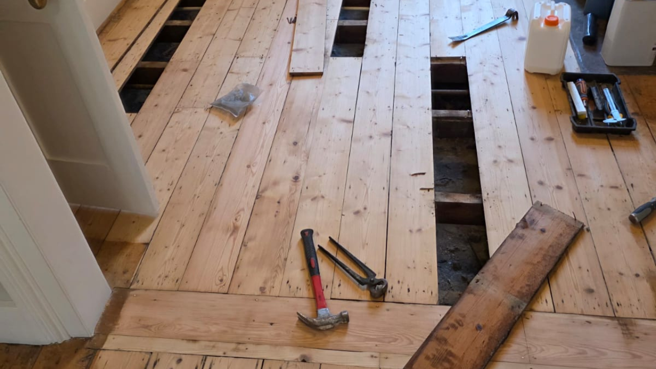 Wood Floor Sanding in Lee with pine softwood floorboards lifted for repairs, showing replacement boards being fitted before sanding and finishing.
