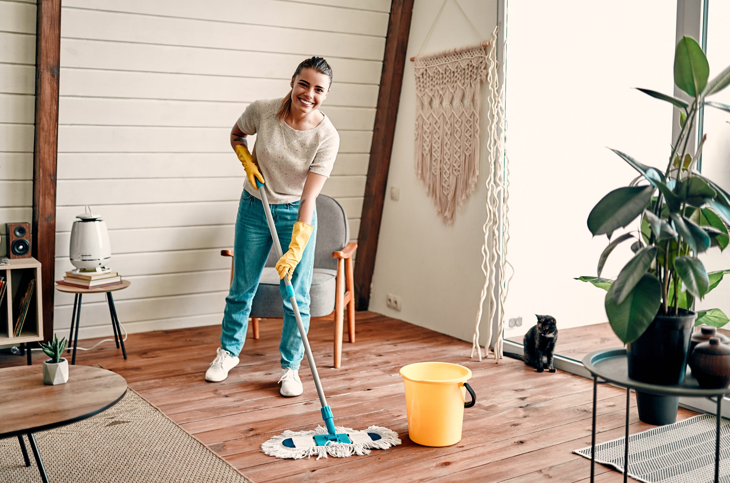 Wood Floor Sanding in Lee on pine softwood living room floorboards, with a woman mopping the freshly restored wooden floor as part of aftercare.